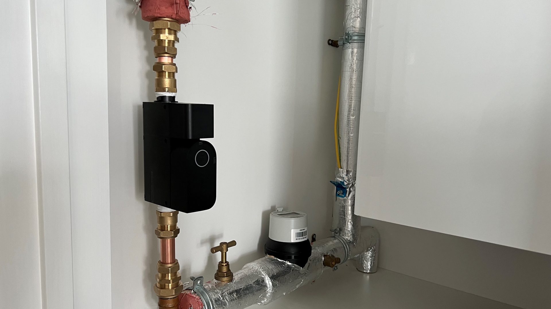 An image of plumbing pipes with a black gadget called the Sonic attached to it
